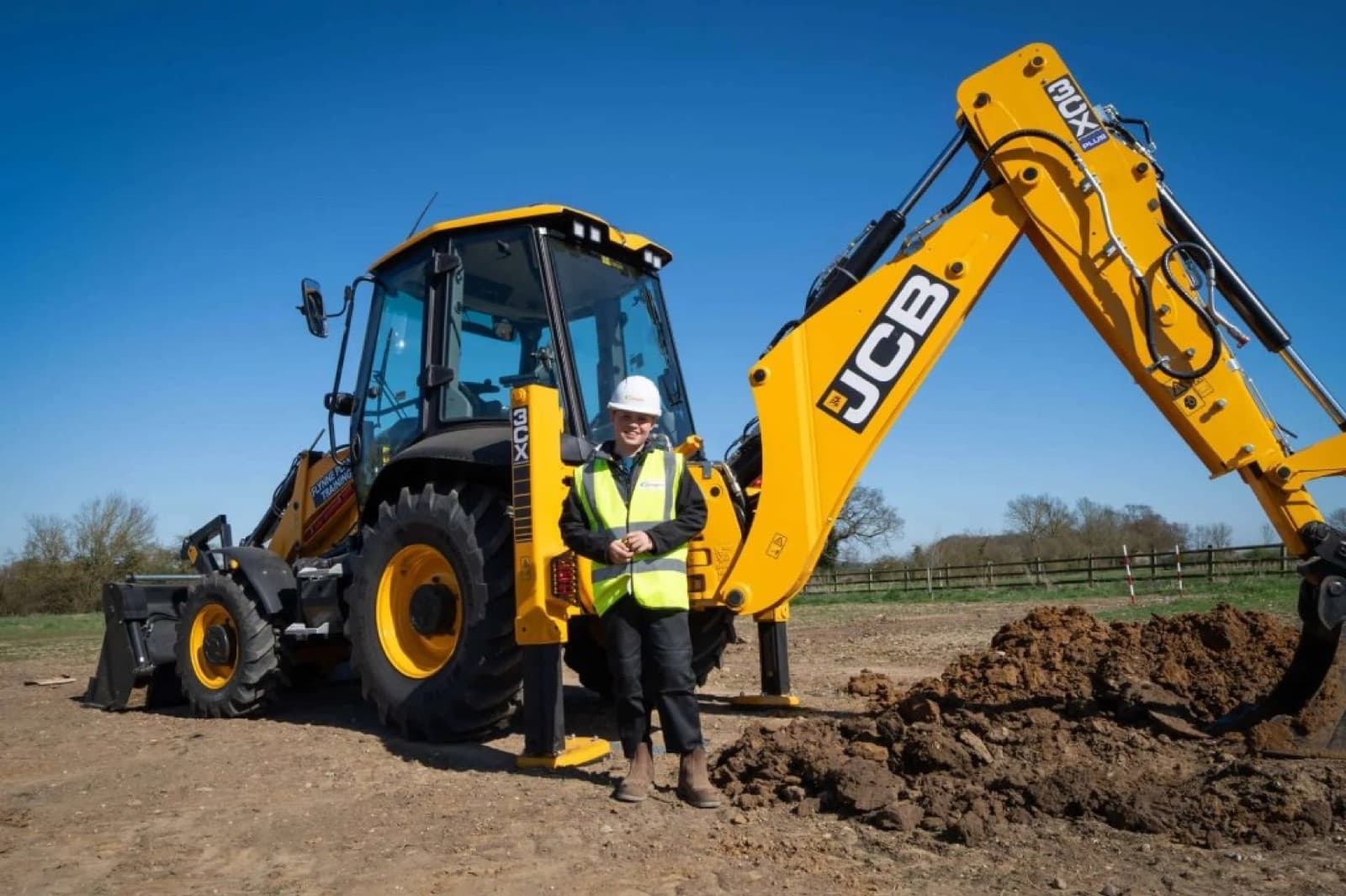 Owner standing beside a JCB excavator financed for their business