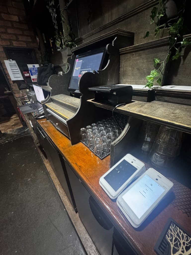A hand holding a card terminal at one of our bar clients