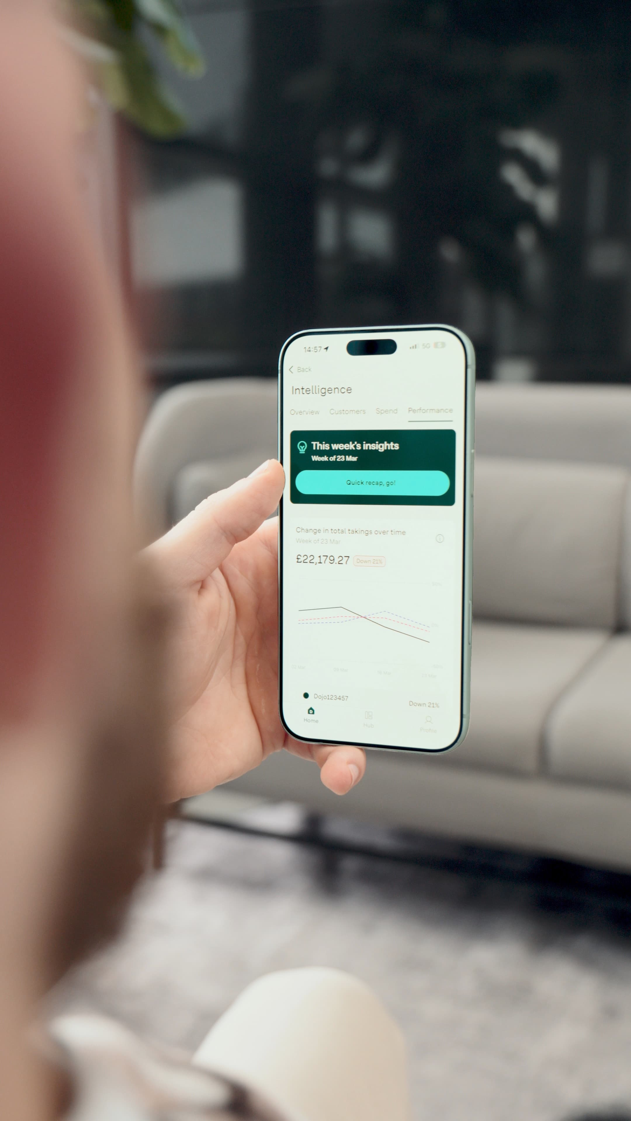Business owner checking weekly takings in the Dojo app on a phone