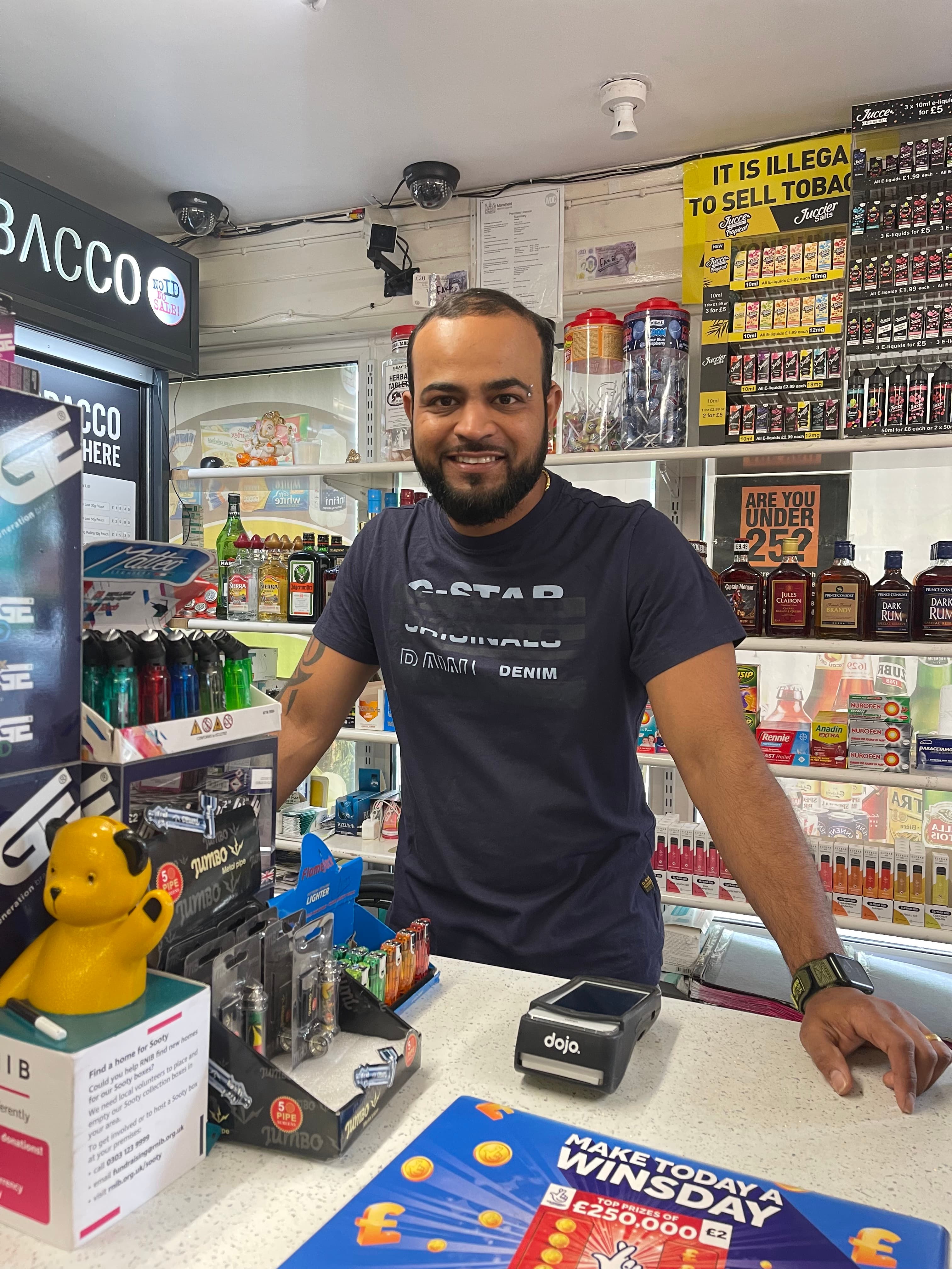 Shopkeeper behind the counter at one of our convenience store clients