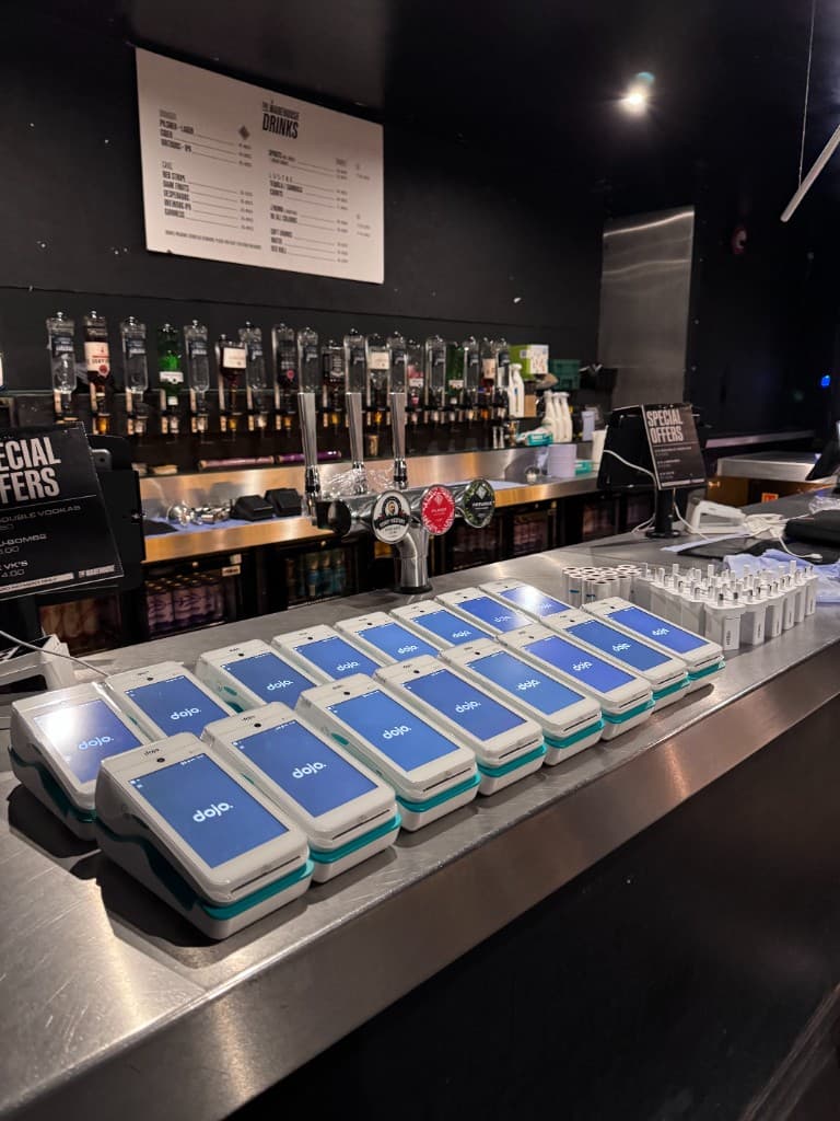 Alex in a warehouse with a line of card terminals ready for a client