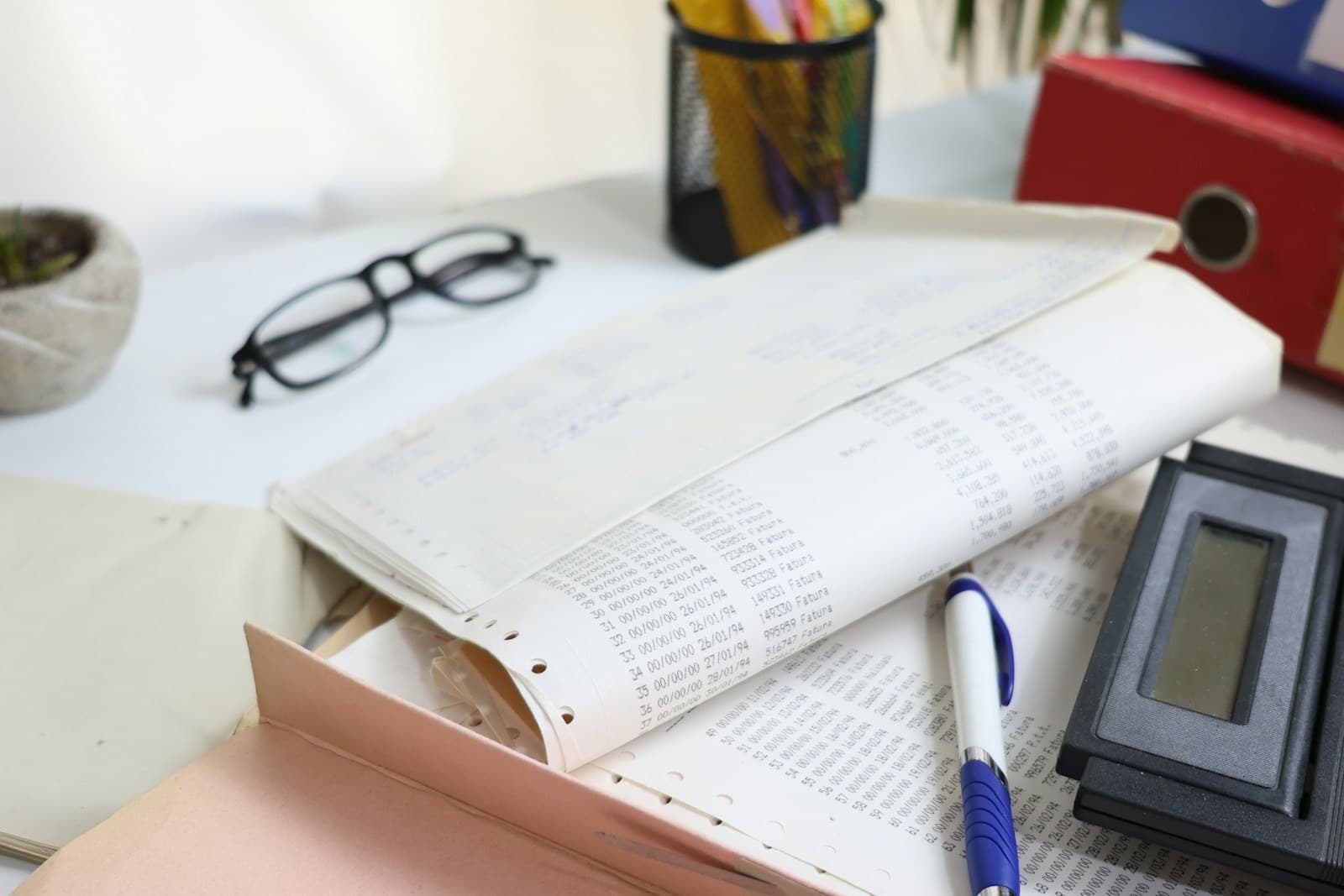 Tax paperwork, ledgers and a calculator on a business desk